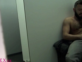 A bear and a young boy have fun at the glory hole at a cruising club.
