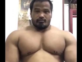 A big and muscular Thai man shows off his muscles.