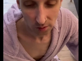 A gay man in a bathrobe gives a blow job.