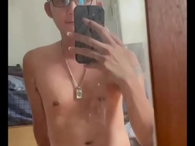 Skinny Asian man masturbates in front of a mirror.